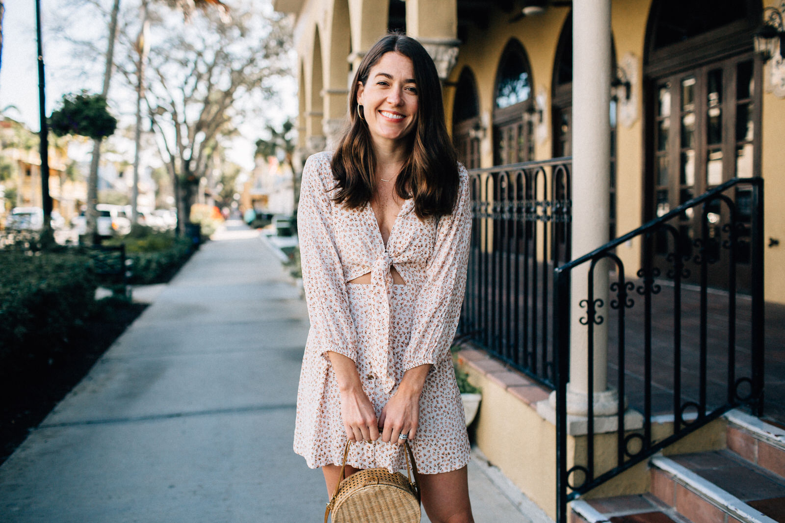 brunette women wearing faithfull the brand trinidad dress and serpui marie wicker handbag in naples florida