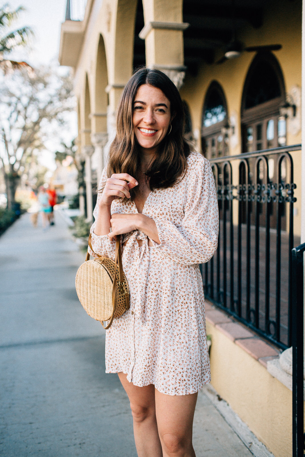 brunette fashion blogger wearing vacation date night outfit in naples florida faithfull the brand trinidad floral print dress serpui marie wicker handbag