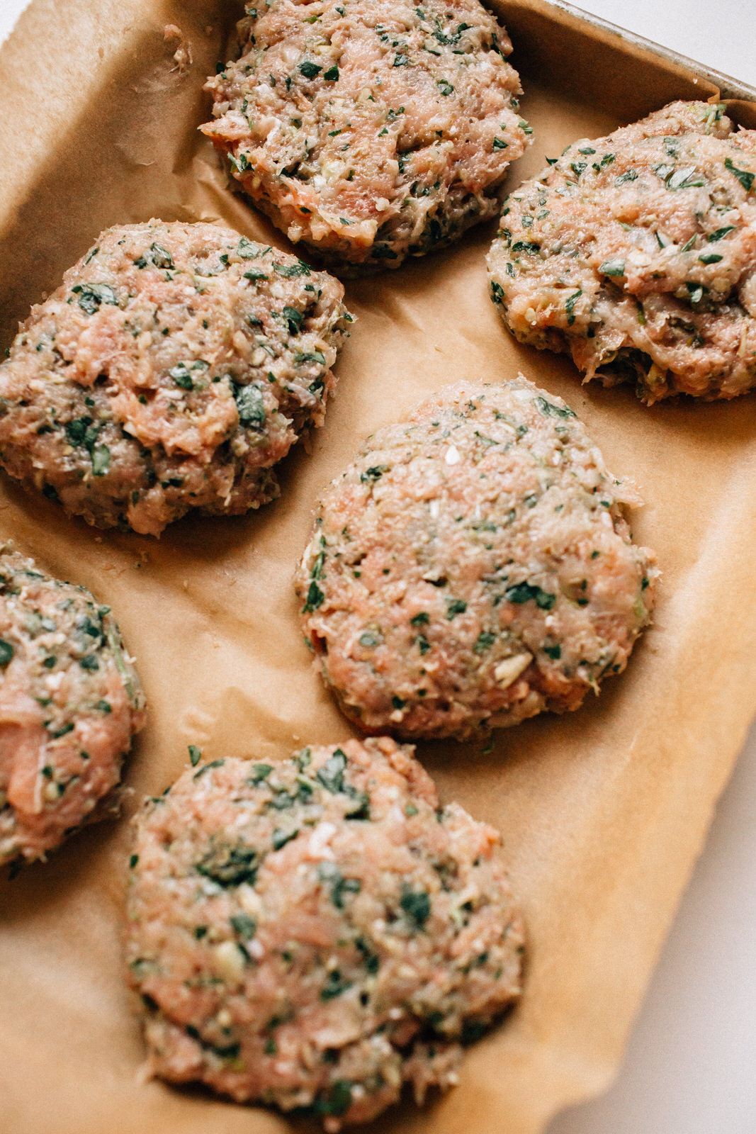 healthy turkey burger patties on roasting pan about to go in oven