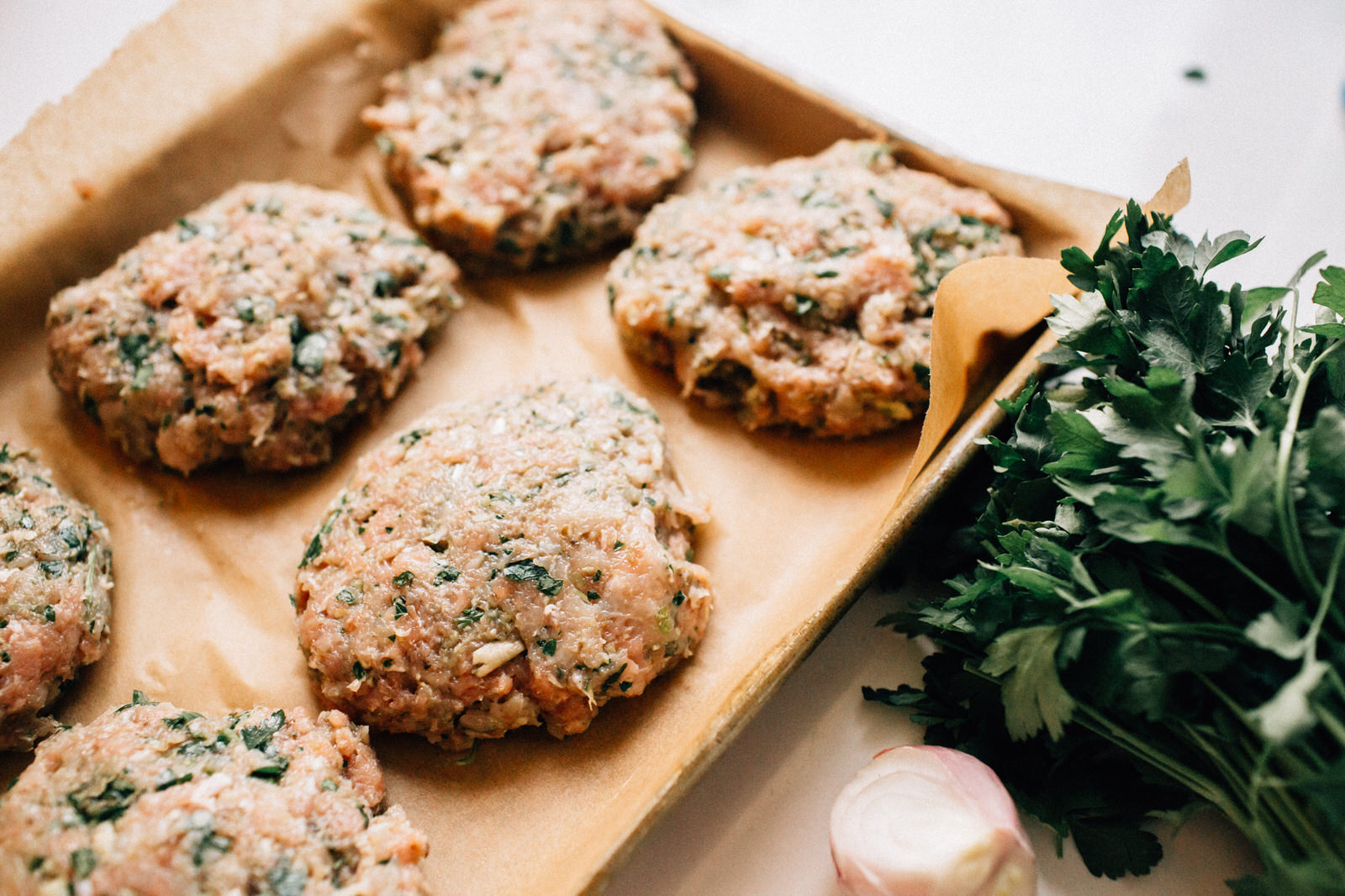 healthy turkey burger patties on parchment paper on roasting pan